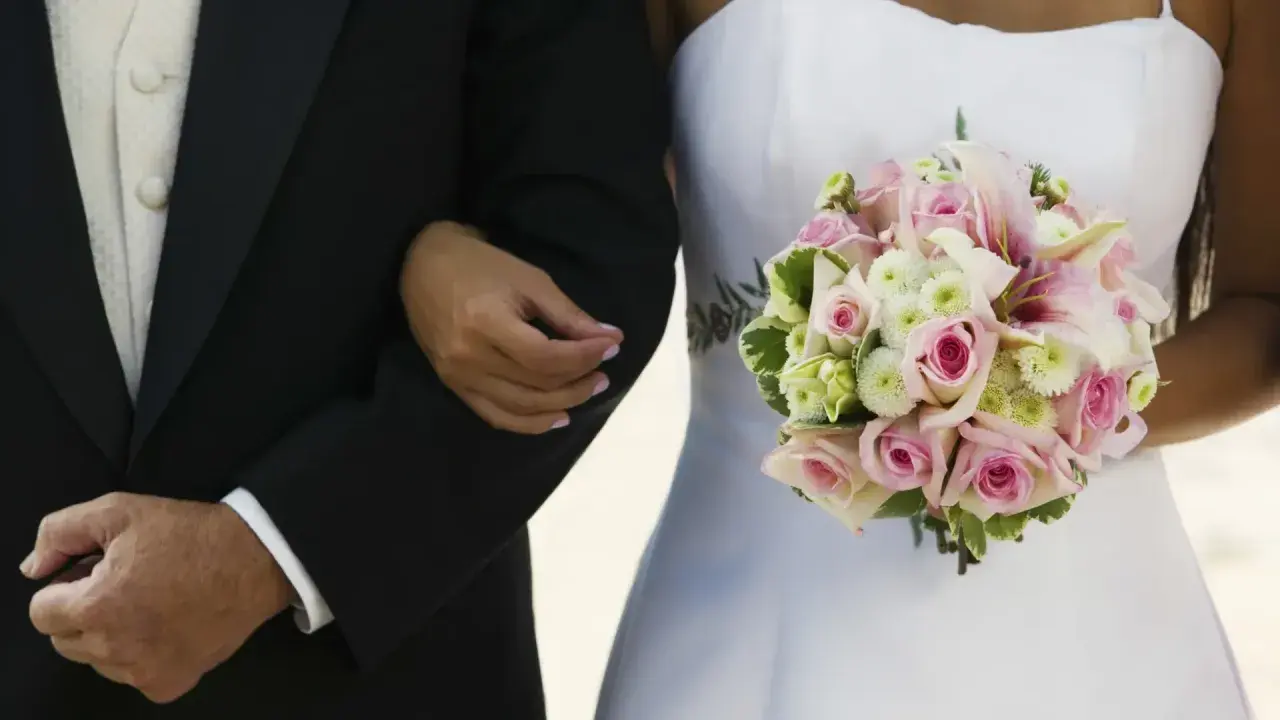 Brautvater spruch: Ein Vater führt seine Tochter zum Altar. Sie hält einen zarten Blumenstrauß.