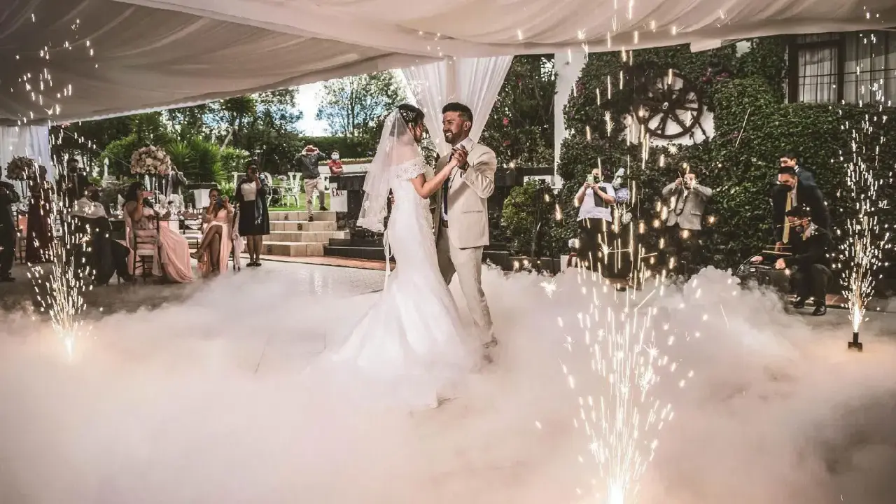 Brautpaar tanzt inmitten von Bodennebel und Funkenregen. Ein romantischer Moment, wie aus umgeschriebene Lieder zur Hochzeit.