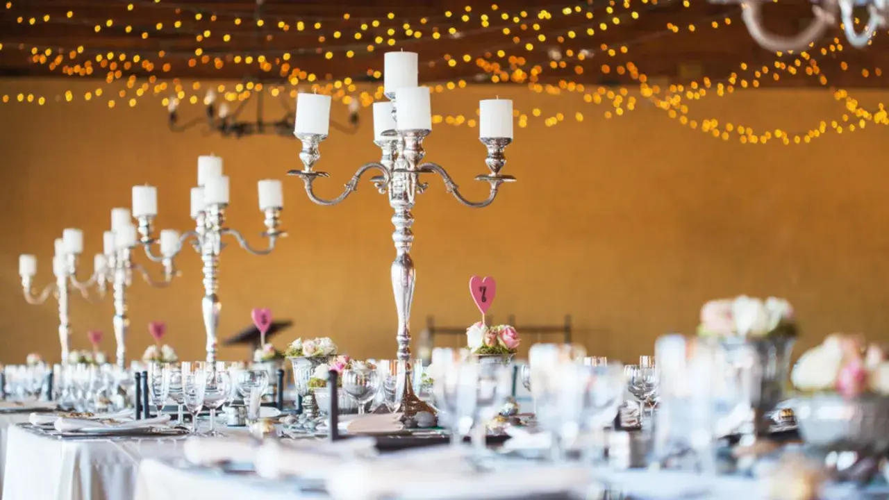 Festlich gedeckte Tafel mit Kerzenleuchtern und Blumenarrangements. Tolle silberhochzeit ideen für eine romantische Feier.