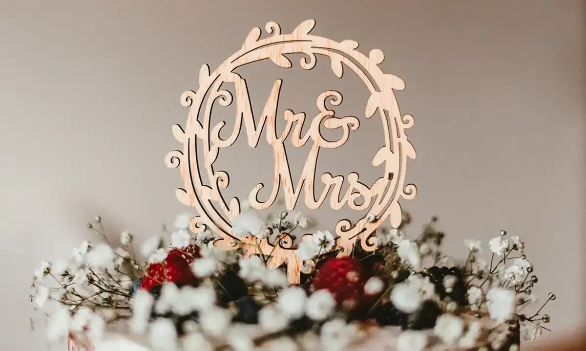 Holzdeko "Mr & Mrs" auf einer Hochzeitstorte mit Beeren und Schleierkraut. Alles Gute zum 5. Hochzeitstag!