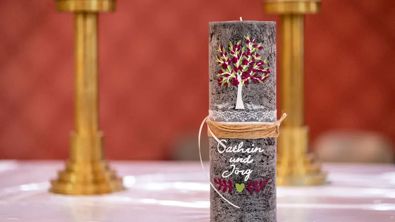 Eine liebevoll gestaltete Hochzeitskerze mit Baum, Namen und Herz. Ein schönes Symbol für die Liebe.
