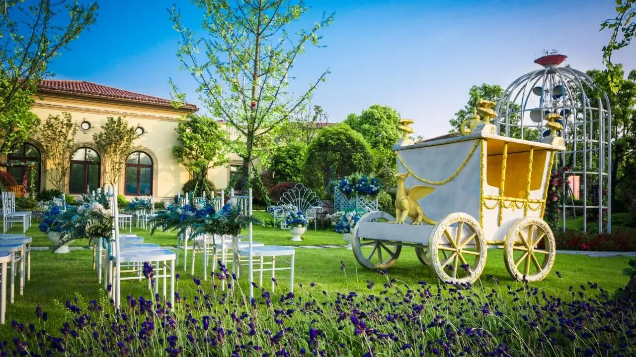 Märchenhafte Kutsche und Sitzreihen im Garten deuten auf eine unkonventionelle Hochzeit hin.