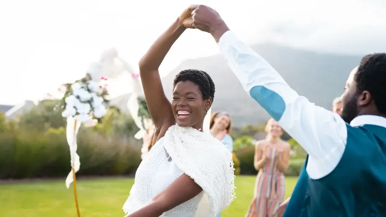 Glückliches Brautpaar tanzt im Freien. Viele Paare entscheiden sich für eine Sommerhochzeit, denn dann heiraten die meisten.