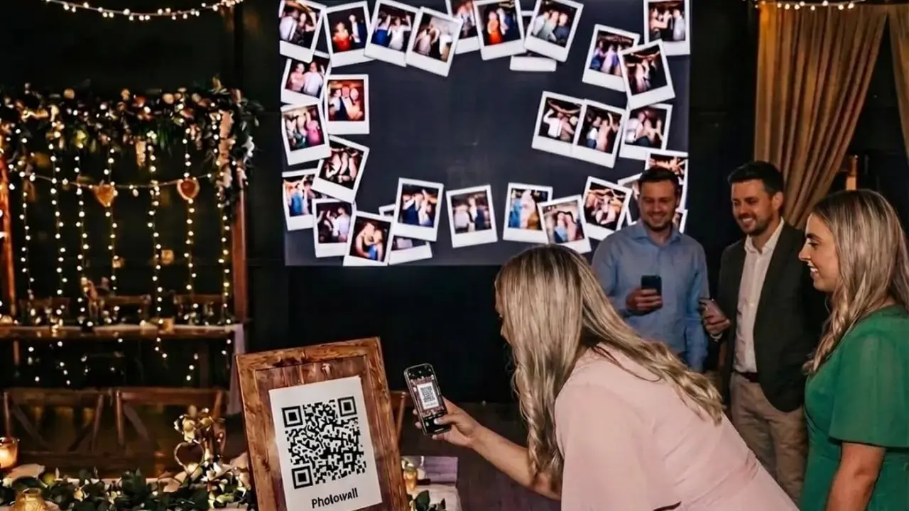 Eine Frau scannt mit ihrem Handy einen QR-Code für eine Photowall. Eine tolle Idee für ein Hochzeitsprogramm mit vielen Erinnerungsfotos.