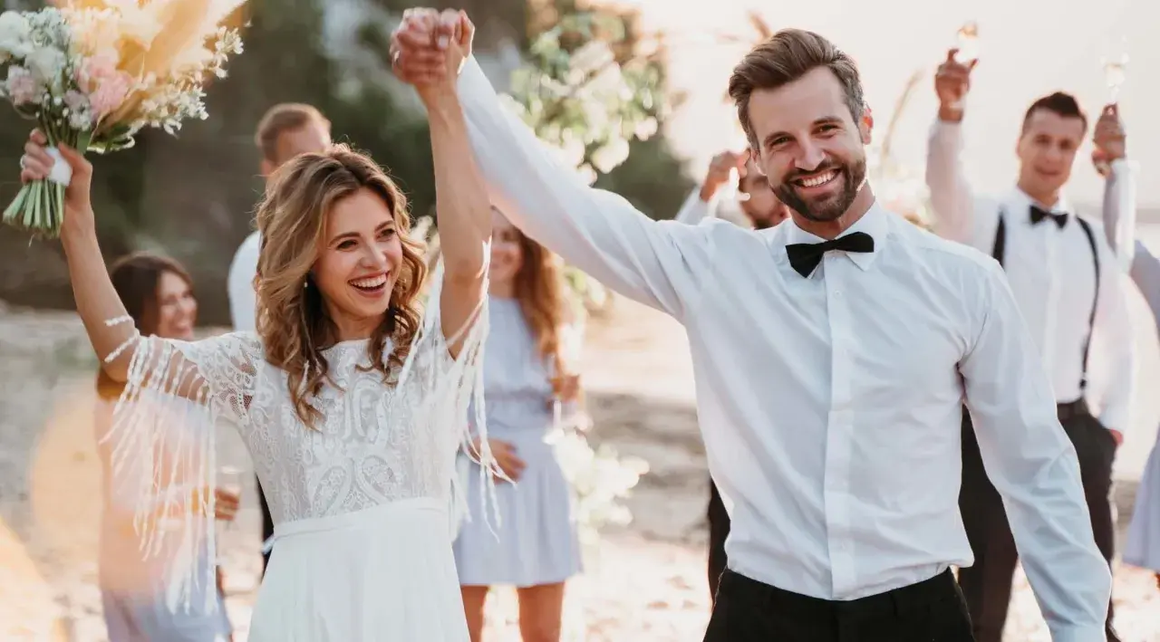 Glückliches Brautpaar feiert am Strand. Mit diesen spartipps hochzeit wird die Feier unvergesslich, ohne das Budget zu sprengen.