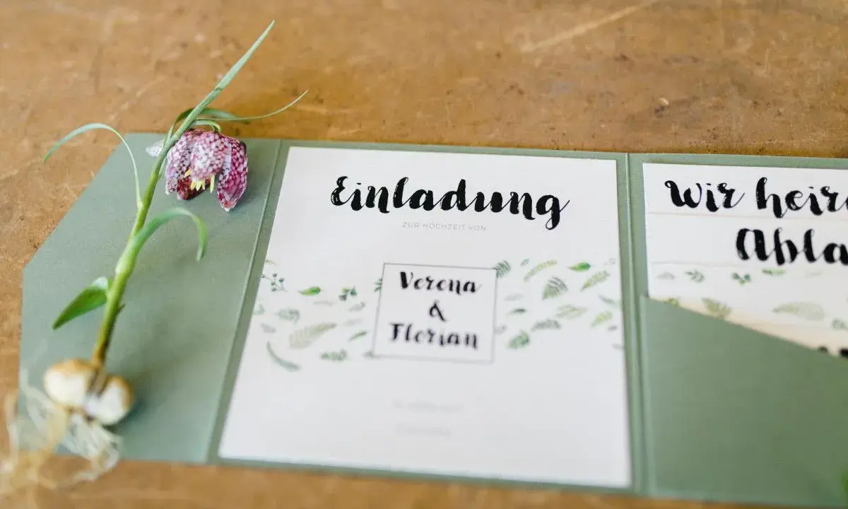 Eine elegante einladung hochzeit vorlage mit floralem Muster und einem Schachbrettblumen-Zweig.