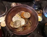 Ein Haufen goldener und silberner Schokoladenmünzen in einer Schale. Sie symbolisieren den Wert und die Bedeutung des 7. Hochzeitstages.