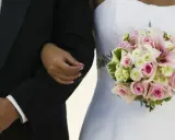 Brautvater spruch: Ein Vater führt seine Tochter zum Altar. Sie hält einen zarten Blumenstrauß.