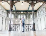 Ein Brautpaar im Stil der 20er Jahre steht sich in einem prachtvollen Gebäude mit Jugendstil-Architektur gegenüber.