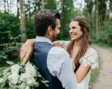 Ein glückliches Brautpaar umarmt sich im Wald. Sie wollten heimlich heiraten und genießen diesen intimen Moment.
