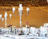 Festlich gedeckte Tafel mit Kerzenleuchtern und Blumenarrangements. Tolle silberhochzeit ideen für eine romantische Feier.