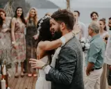 Glückliches Brautpaar umarmt sich, Gäste im Hintergrund. Perfekt für zitate hochzeitskarte.