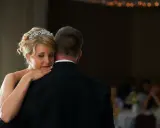 Ein zärtlicher Vater-Tochter-Tanz. Die Braut mit Diadem lehnt sich an ihren Vater, der einen schwarzen Anzug trägt.