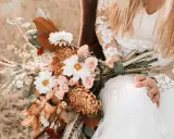 Brautstrauß mit Dahlien, Rosen und Orchideen in warmen Tönen. Originelle Ideen Hochzeit für einen rustikalen Look.