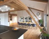 Rustikale Holzbalken und ein langer Esstisch schaffen eine gemütliche Atmosphäre, perfekt für eine Scheune Hochzeit.