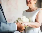 Ein glückliches Paar feiert seinen 50. Hochzeitstag. Die Bedeutung dieses Meilensteins wird durch die Ringe und den Blumenstrauß unterstrichen.