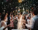 Fröhliche wedding party mit Funken sprühenden Wunderkerzen und flatternden Schmetterlingen aus Papier.