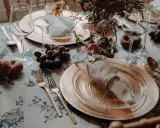 Herbstliche tischdeko hochzeit mit Trauben, Pfirsichen und goldenem Geschirr.