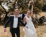 Glückliches Brautpaar im Freien, umgeben von Seifenblasen. Sie strahlen und scheinen gerade ihren Hochzeitstanz gelernt zu haben und feiern diesen besonderen Moment.