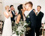Brautpaar küsst sich, Gäste applaudieren. Der Beginn der standesamtlichen hochzeit ablauf ist ein emotionaler Moment.