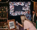 Eine Frau scannt mit ihrem Handy einen QR-Code für eine Photowall. Eine tolle Idee für ein Hochzeitsprogramm mit vielen Erinnerungsfotos.