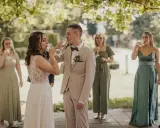 Brautpaar und Gäste stoßen beim Sekt­empfang Hochzeit an.