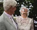 Ein glückliches Paar, meine Eltern, feiern diamantene Hochzeit. Konfetti fliegt durch die Luft, während sie sich anlächeln.
