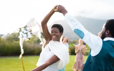 Glückliches Brautpaar tanzt im Freien. Viele Paare entscheiden sich für eine Sommerhochzeit, denn dann heiraten die meisten.