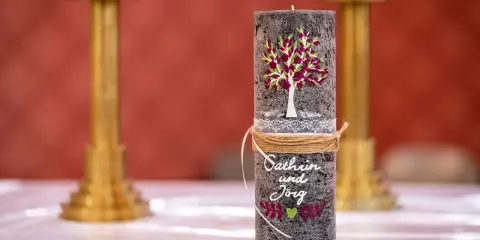Eine liebevoll gestaltete Hochzeitskerze mit Baum, Namen und Herz. Ein schönes Symbol für die Liebe.