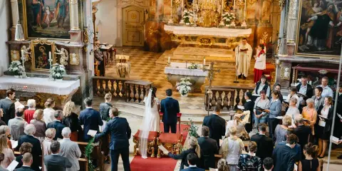 Hochzeit in der Kirche. Ein Paar heiratet, obwohl die Firmung nicht stattgefunden hat. Gäste verfolgen die Zeremonie.