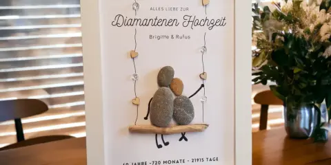Gerahmtes Bild mit Steinfiguren, die eine diamantene Hochzeit feiern. 60 Jahre sind diamantene Hochzeit.