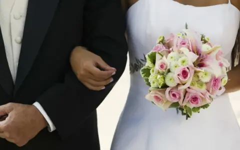 Brautvater spruch: Ein Vater führt seine Tochter zum Altar. Sie hält einen zarten Blumenstrauß.