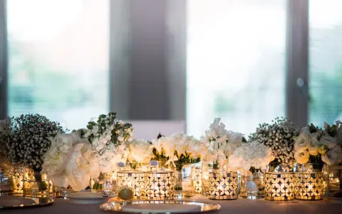 Festlich gedeckter Tisch mit weißen Blumen und Kerzen. Ein Symbol für die Bedeutung von 15 Jahren verheiratet zu sein, voller Liebe und Licht.