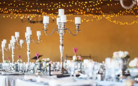 Festlich gedeckte Tafel mit Kerzenleuchtern und Blumenarrangements. Tolle silberhochzeit ideen für eine romantische Feier.