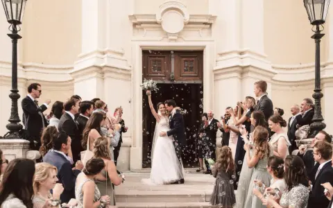 Ein strahlendes Brautpaar verlässt die Kirche, umgeben von Seifenblasen und jubelnden Gästen. Eine klassische Hochzeit voller Freude und Romantik.