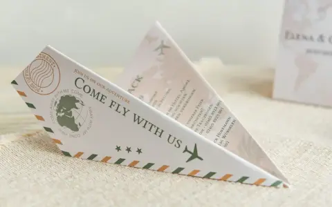 Einladung zur Hochzeit im Papierflieger-Design. Der lustige Text "Come fly with us" lädt zur gemeinsamen Reise ein.