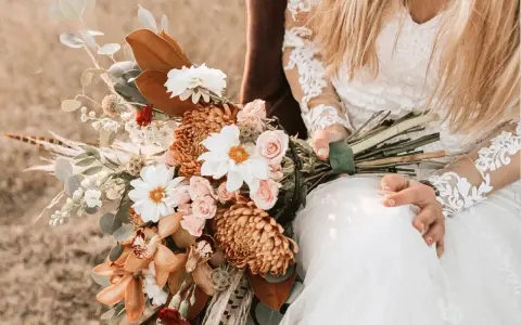 Brautstrauß mit Dahlien, Rosen und Orchideen in warmen Tönen. Originelle Ideen Hochzeit für einen rustikalen Look.