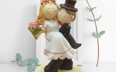 Ein süßes Brautpaar basteln: Die Figur zeigt ein lachendes Brautpaar im Hochzeitsanzug und Brautkleid, das sich umarmt.