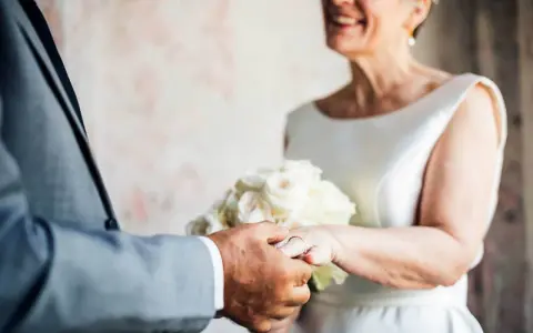 Ein glückliches Paar feiert seinen 50. Hochzeitstag. Die Bedeutung dieses Meilensteins wird durch die Ringe und den Blumenstrauß unterstrichen.