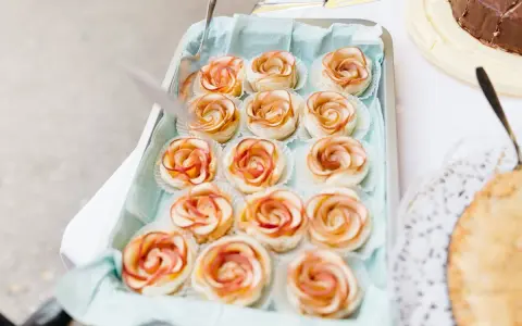 Kleine Apfelrosen-Törtchen in einer Schale, perfekt für eine Feier, vielleicht zum Anlass zehn Jahre verheiratet.