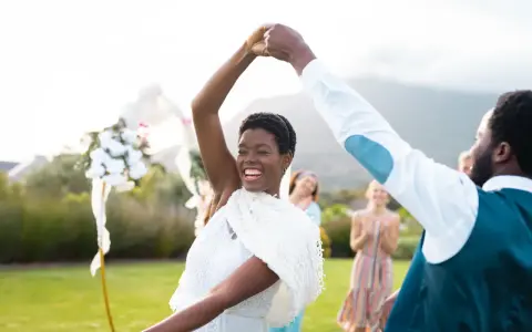 Glückliches Brautpaar tanzt im Freien. Viele Paare entscheiden sich für eine Sommerhochzeit, denn dann heiraten die meisten.