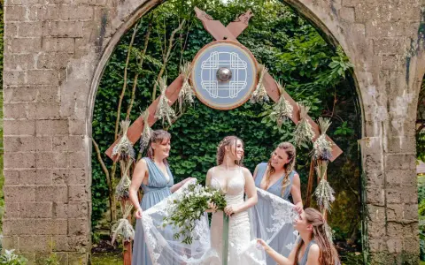Braut und Brautjungfern unter einem Torbogen mit Wikinger-Schild. Eine stimmungsvolle Wikinger-Hochzeit.