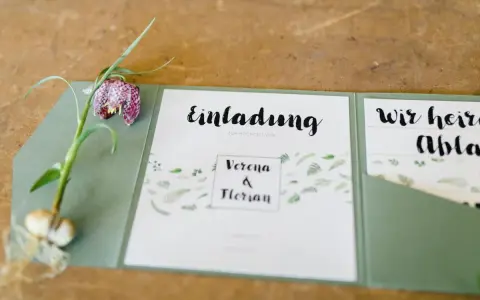 Eine elegante einladung hochzeit vorlage mit floralem Muster und einem Schachbrettblumen-Zweig.