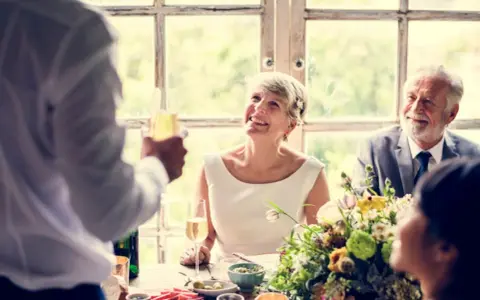 Ein glückliches Paar feiert seinen 40. Hochzeitstag. Die Bedeutung von 40 Jahren Ehe wird durch ihre strahlenden Gesichter und den Toast mit Champagner unterstrichen.