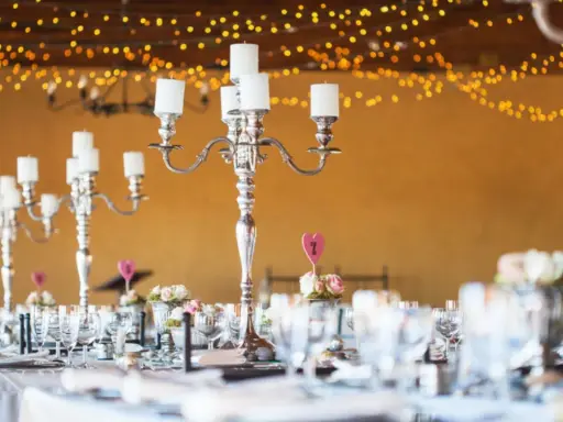 Festlich gedeckte Tafel mit Kerzenleuchtern und Blumenarrangements. Tolle silberhochzeit ideen für eine romantische Feier.