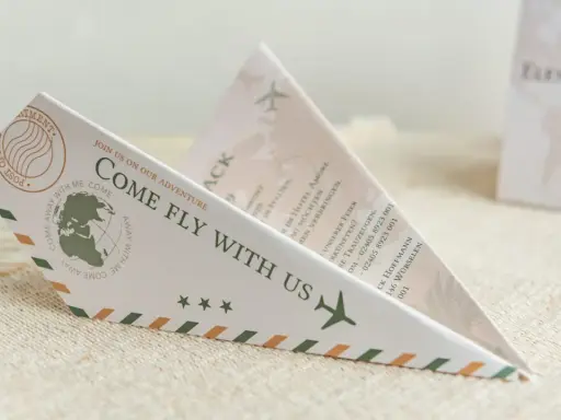 Einladung zur Hochzeit im Papierflieger-Design. Der lustige Text "Come fly with us" lädt zur gemeinsamen Reise ein.