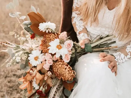 Brautstrauß mit Dahlien, Rosen und Orchideen in warmen Tönen. Originelle Ideen Hochzeit für einen rustikalen Look.
