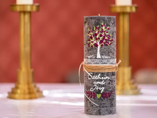 Eine liebevoll gestaltete Hochzeitskerze mit Baum, Namen und Herz. Ein schönes Symbol für die Liebe.