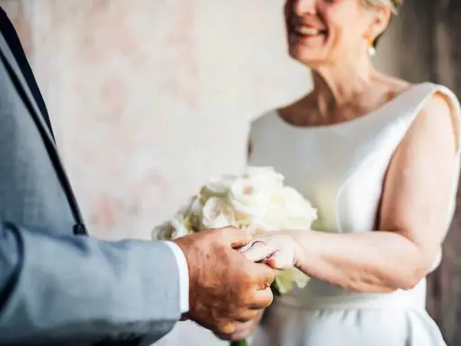Ein glückliches Paar feiert seinen 50. Hochzeitstag. Die Bedeutung dieses Meilensteins wird durch die Ringe und den Blumenstrauß unterstrichen.