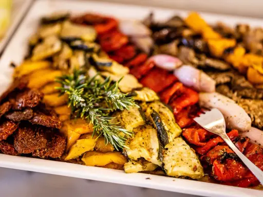Buntes Buffet mit gegrilltem Gemüse und Kräutern – tolle hochzeitsessen ideen für ein Festmahl.